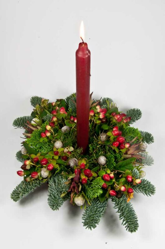 kerststukje met rode kaars en levende decoratie